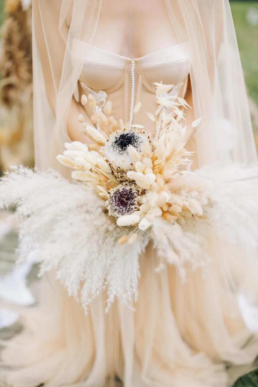 Delicate bridal bouquet arranged beside wedding details