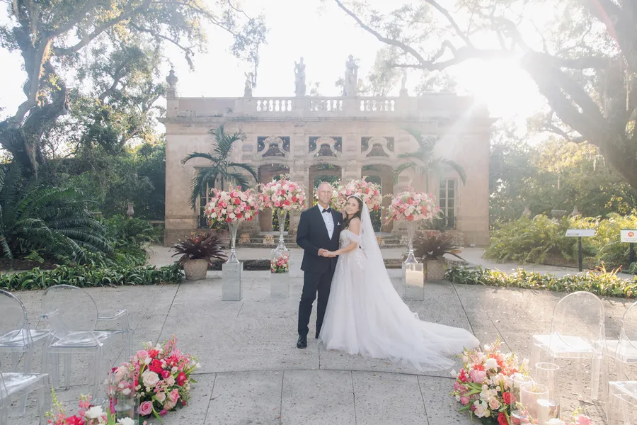 Newlyweds standing at an elegant garden wedding entrance