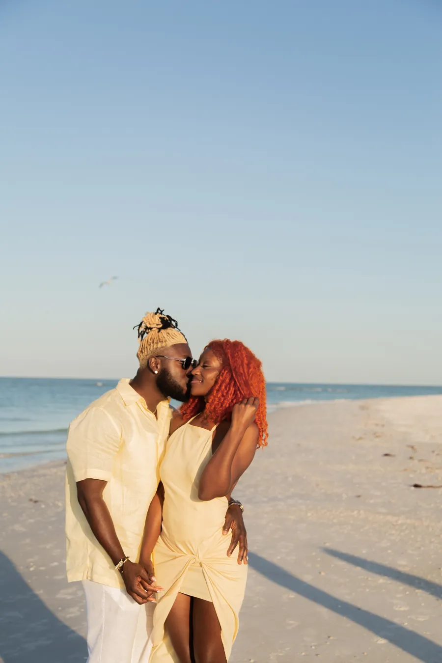 Couple embracing during a warm sunset beach photo session