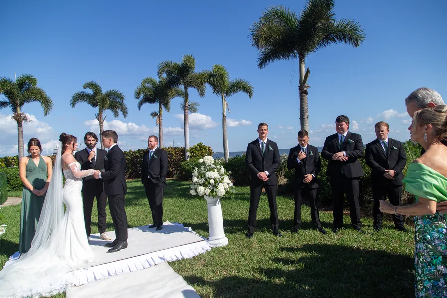 Outdoor wedding ceremony with palm trees and blue sky