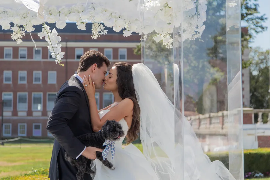 Newlyweds embracing at the flower-lined ceremony aisle — David and Katia wedding